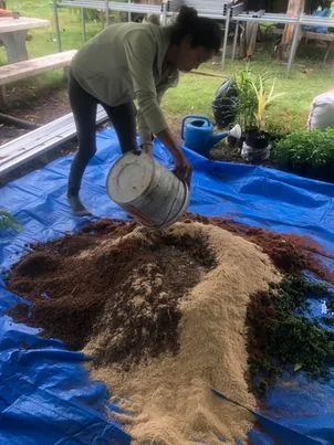 Suwan melange les matieres organiques pour le compostage