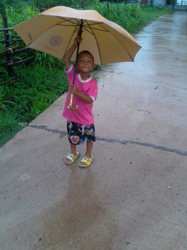 Un enfant de l'Isan, sous un parapluie plus grand que lui...